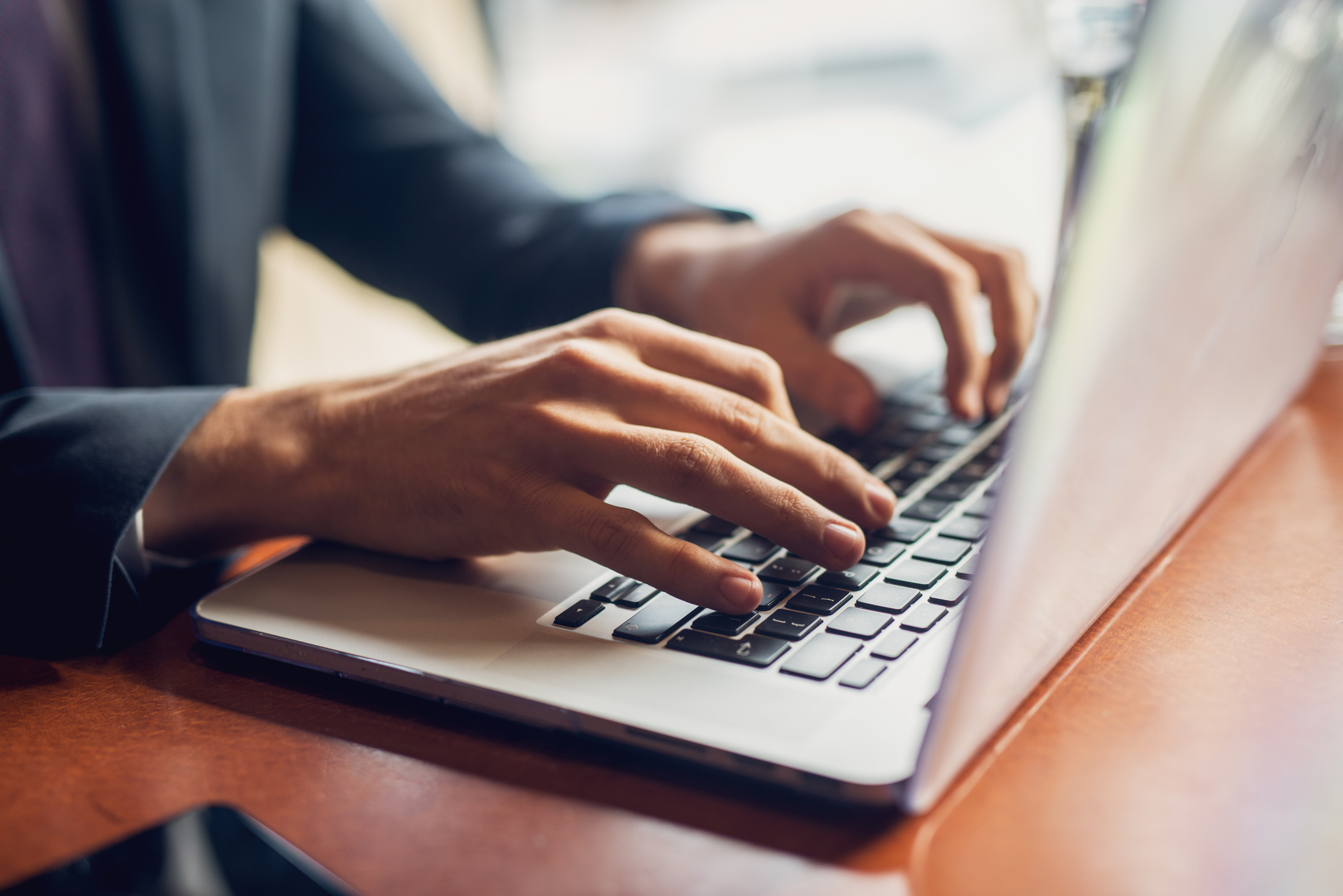 Gros plan sur les mains d’un homme d’affaires tapant sur un clavier.